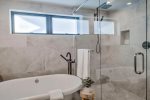 Lush soaking tub and glass door shower 